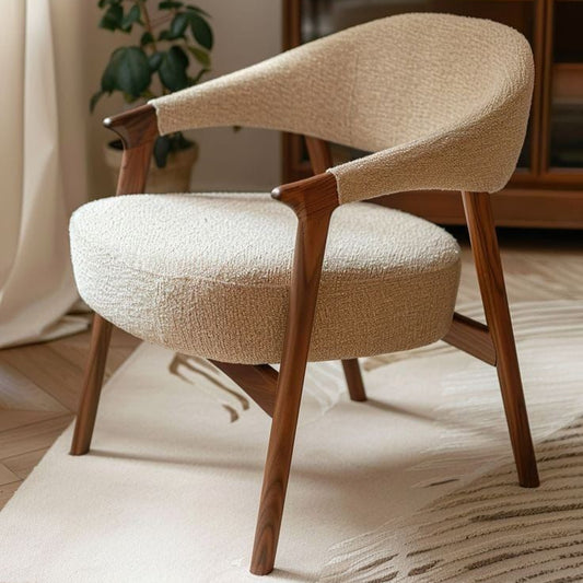 Beige armchair with wooden legs in a room with a bookshelf and plant