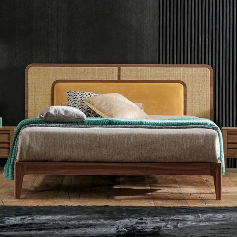 Modern bedroom with a bed, nightstands, and decorative pillows against a dark wall.