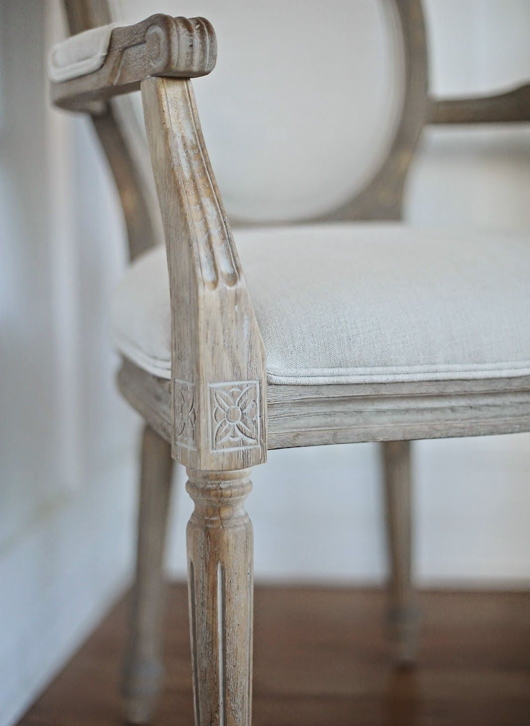 Close-up of a wooden chair with intricate carvings on a blurred background