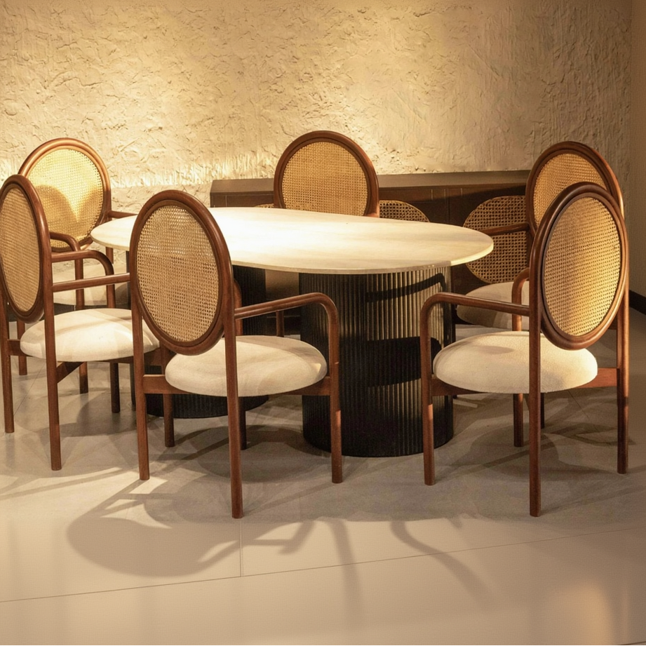 Dining table with six chairs in a room with textured walls.