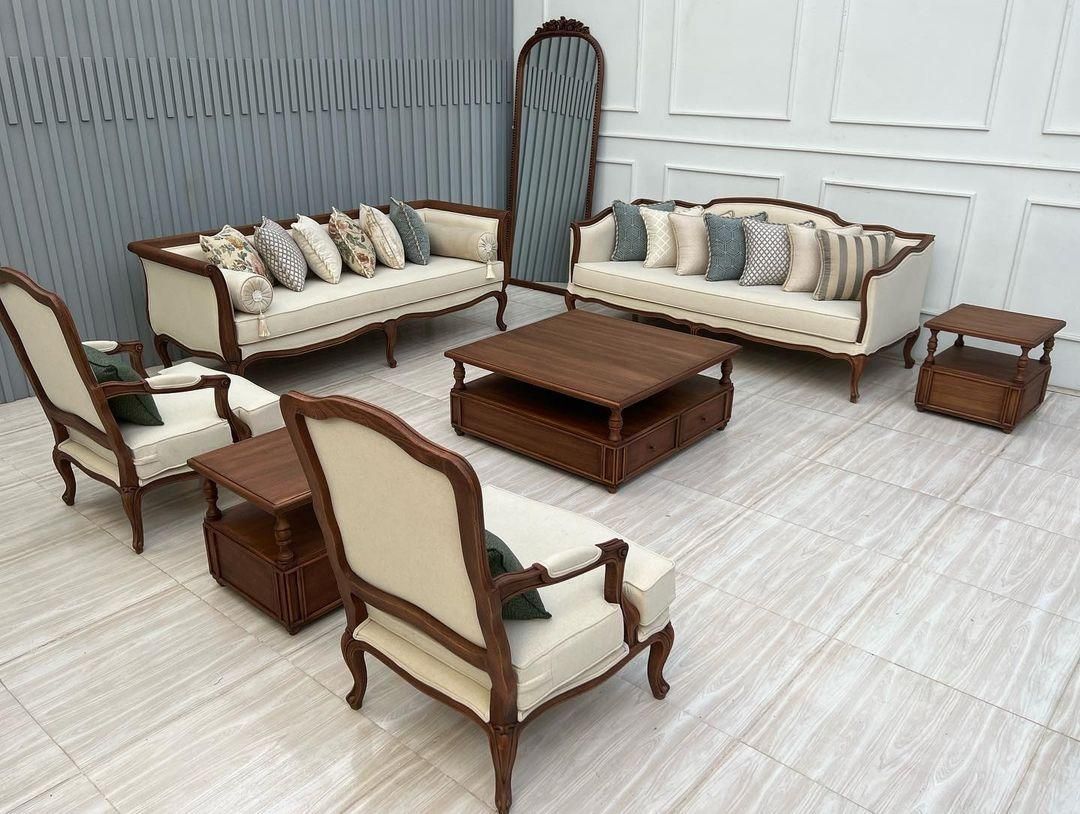 Luxury living room furniture set with sofas, chairs, and coffee tables in a well-lit room.