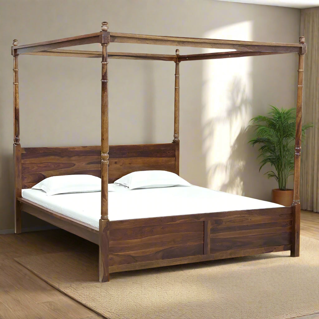 Wooden canopy bed with white bedding against a plain wall.