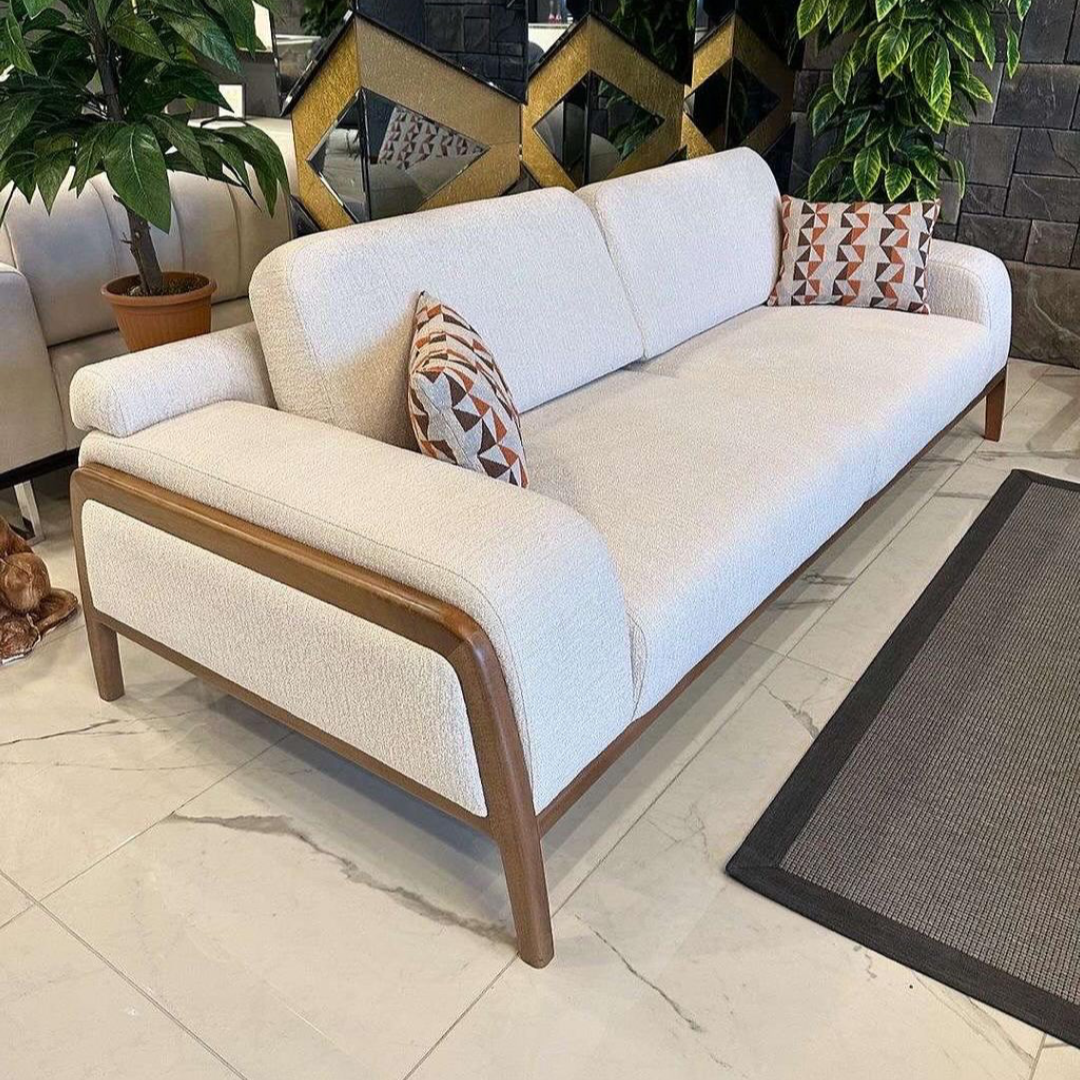 White sofa with wooden armrests in a room 